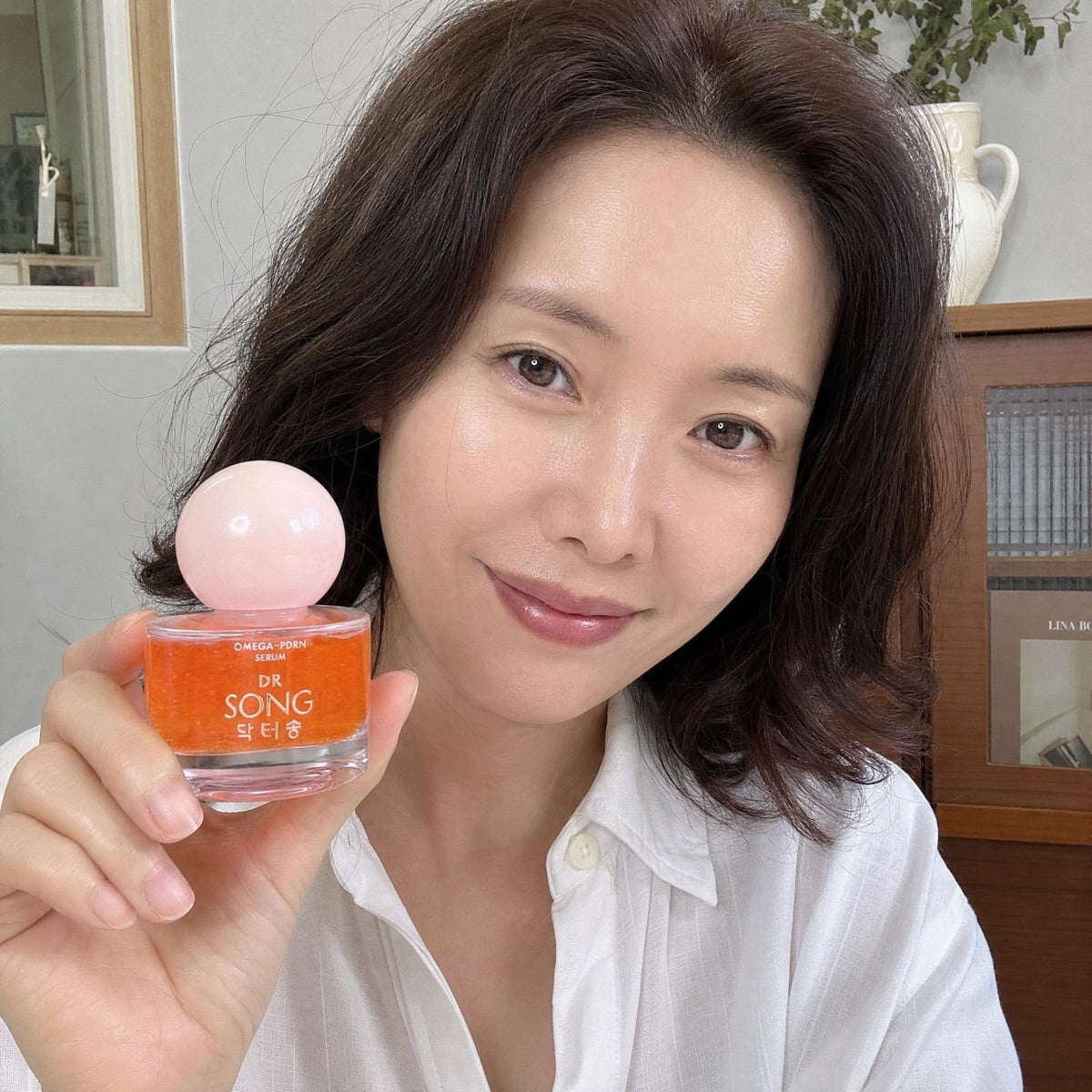 Woman holding Dr Song Omega-PDRN Serum